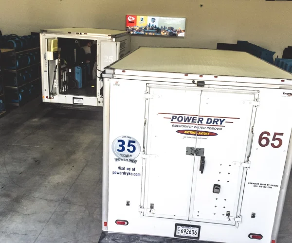 Back of power dry company truck parked in water damage restoration equipment warehouse